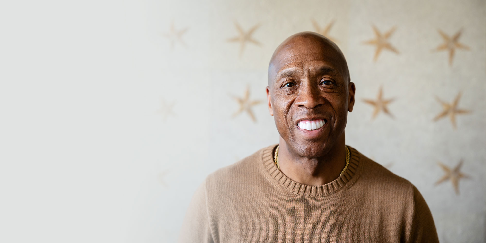 headshot of patient smiling brightly within their home